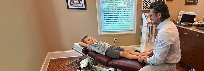 Chiropractor Southern Pines NC Thomas McKay Jr. Adjusting Child Chiropractor Thomas McKay Jr. Adjusting Childs Leg