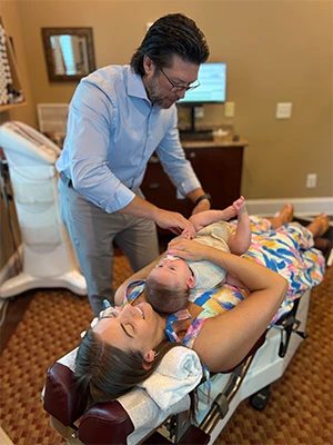 Chiropractor Southern Pines NC Thomas McKay Jr. With Mother Patient And Her Child HP Chiropractor Thomas McKay Jr. With Mother Patient And Her Child